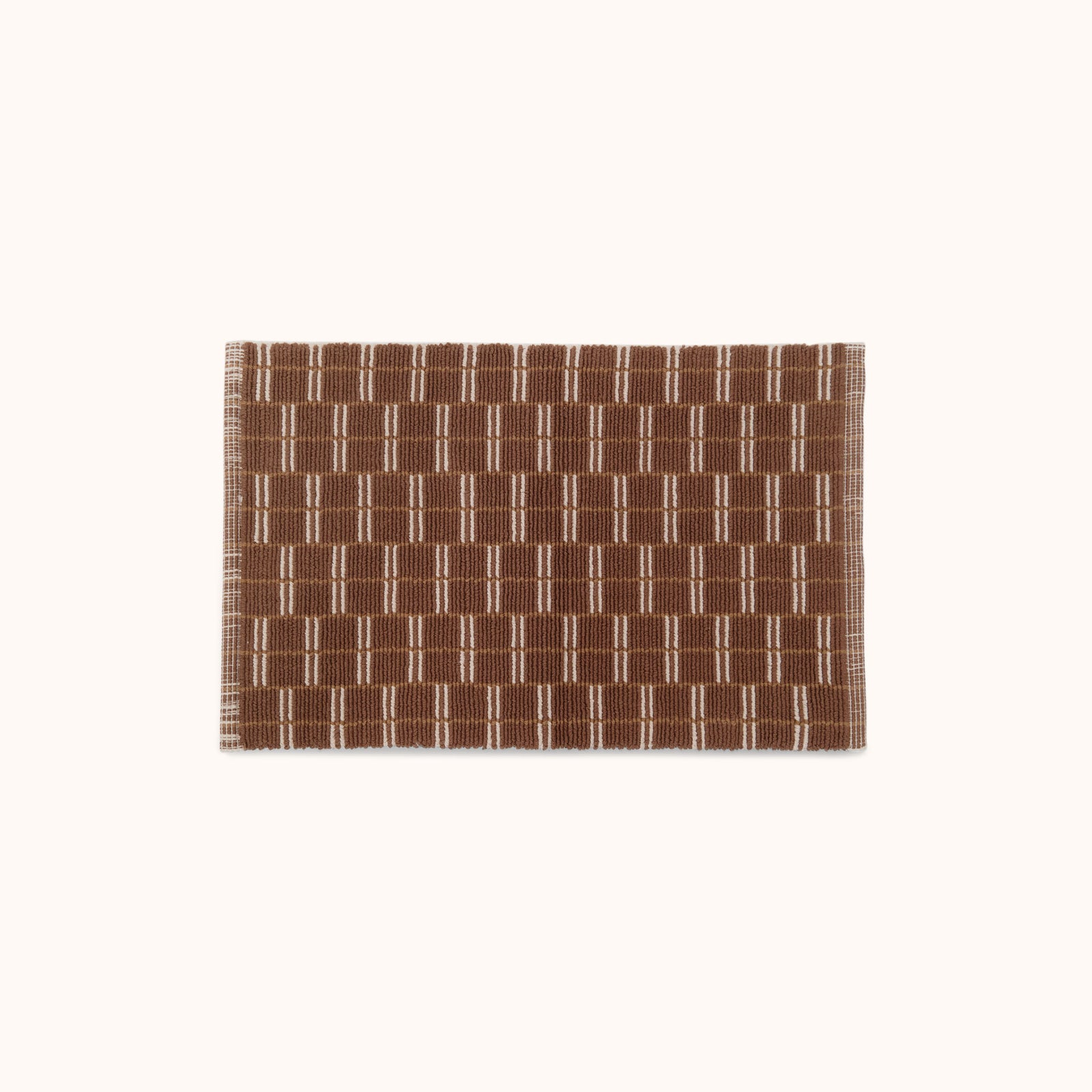 A rectangular brown and natural mat with a geometric pattern.
