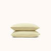 A set of two Límon / soft yellow pillowcases made from organic matte sateen fabric, displayed against a white background.