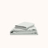 A folded sheet set in Mist made from organic matte sateen fabric.