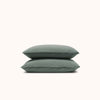 A set of two green matte sateen Pacific pillowcases stacked neatly against a white background.