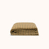 Folded striped coverlet on a plain background, displaying a pattern of brown/beige and blue/green stripes with details that suggest a vintage design.