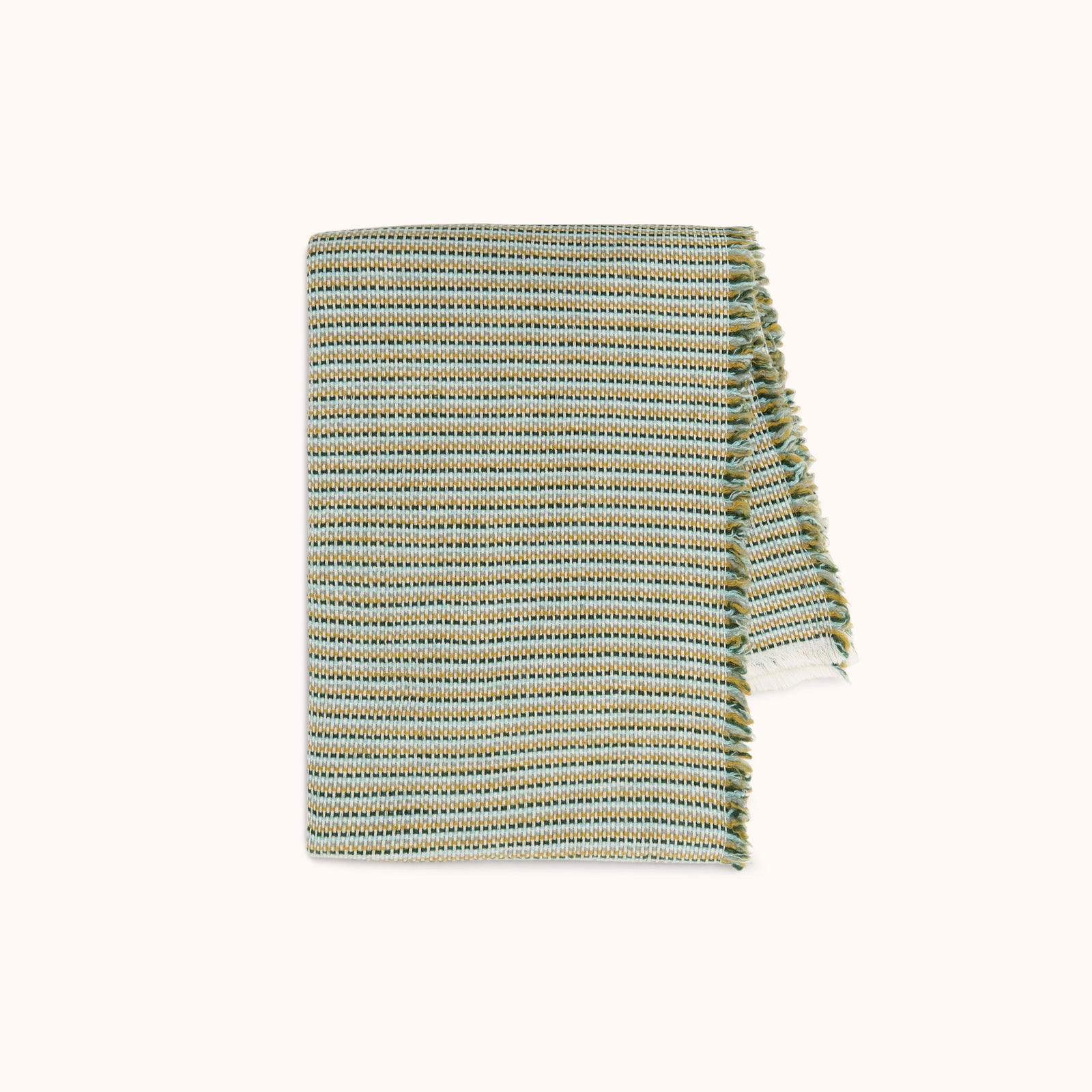 A blanket with a subtle woven stripe pattern in golden yellow, blue, and green hues.