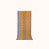 A runner  with a geometric pattern featuring blue squares on a camel brown background.