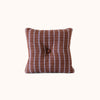 Brown and lavender check pillow with a button on a white background