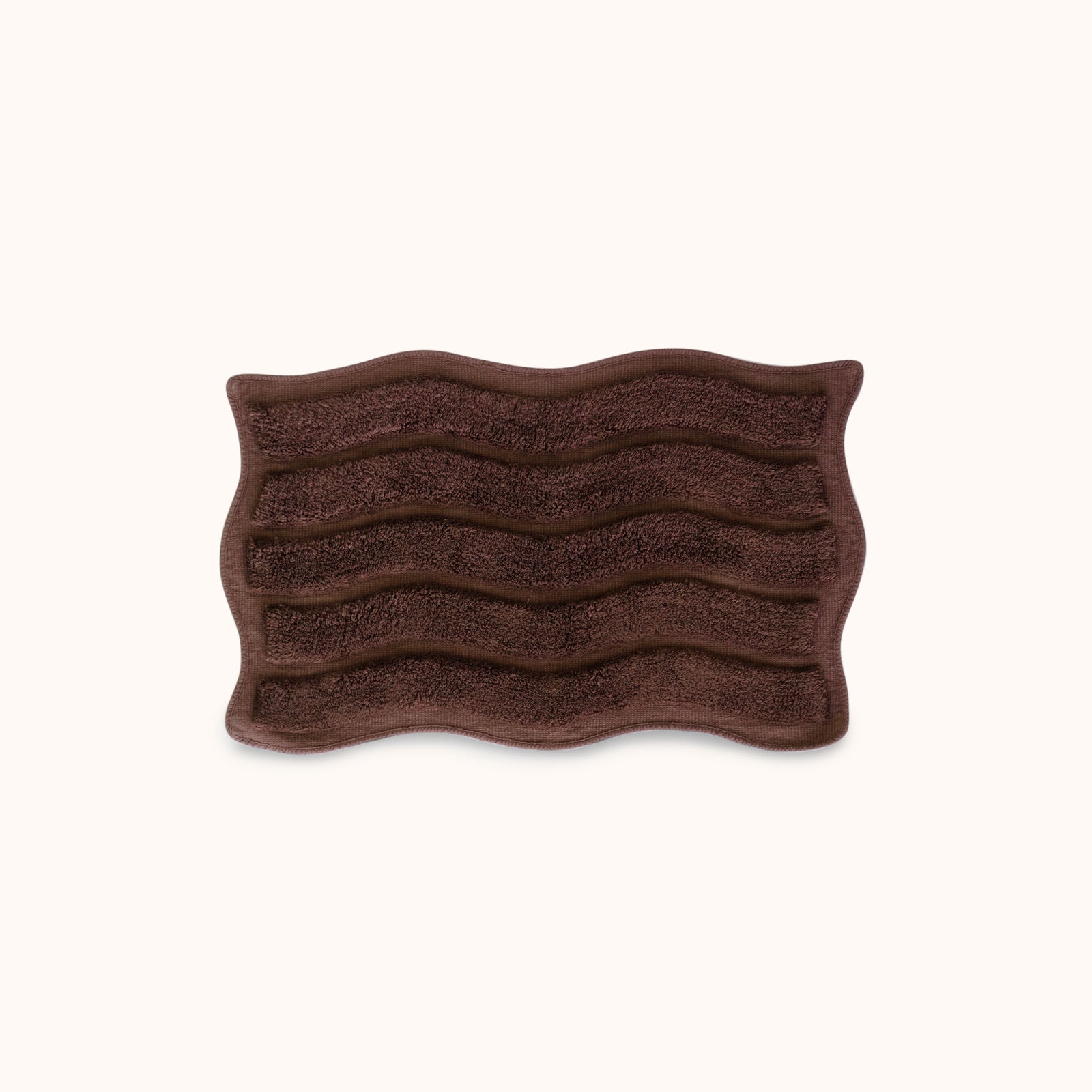 Brown textured bath mat with wavy pattern and alternating shag heights on a white background