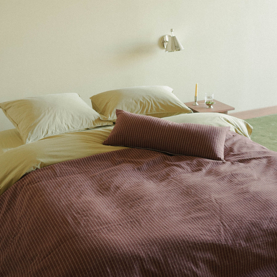 Morrow Soft Goods Juno Check Duvet and Lumbar with Organic Percale Sheets in Pale Olive bed lifestyle image