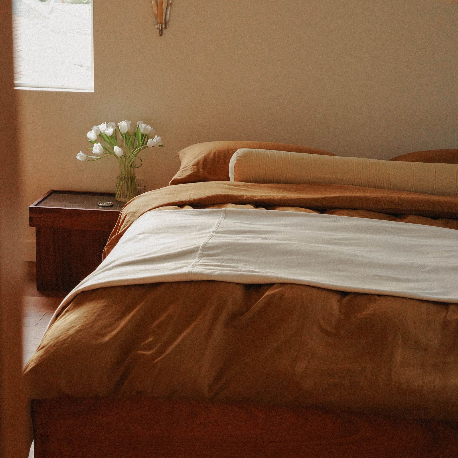 Morrow Soft Goods Hemp Cotton Duvet Cover in Willow, Marta Coverlet in White and Devi Bolster in Maiz. Bedroom Lifestyle Image 