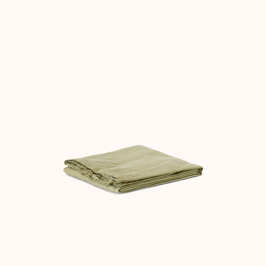 A folded shower curtain with green stripe pattern on a white background.