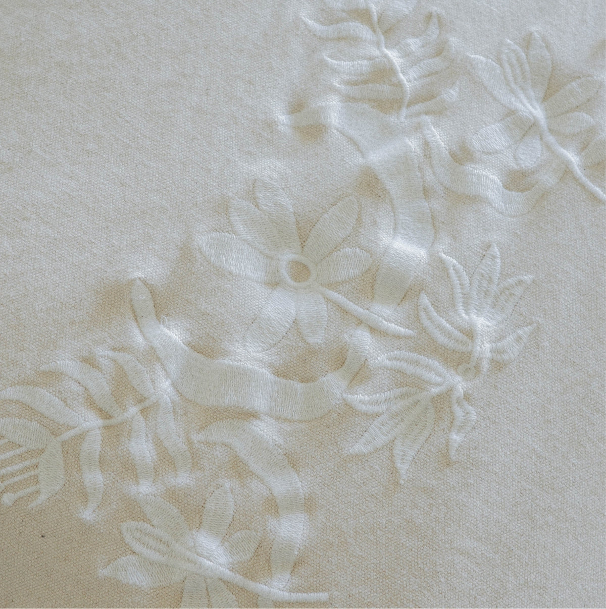 Detail of soft white Marta coverlet floral embroidery 