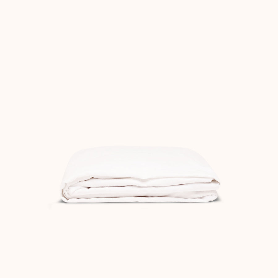 A folded white fitted matte sateen sheet on a white background.