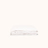 A folded white matte sateen fitted sheet on a plain background.