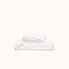 A folded white matte sateen sheet set on a white background